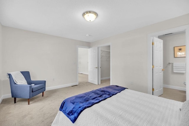 carpeted bedroom with a closet, a spacious closet, and connected bathroom