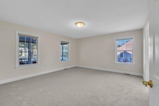 spare room featuring light colored carpet