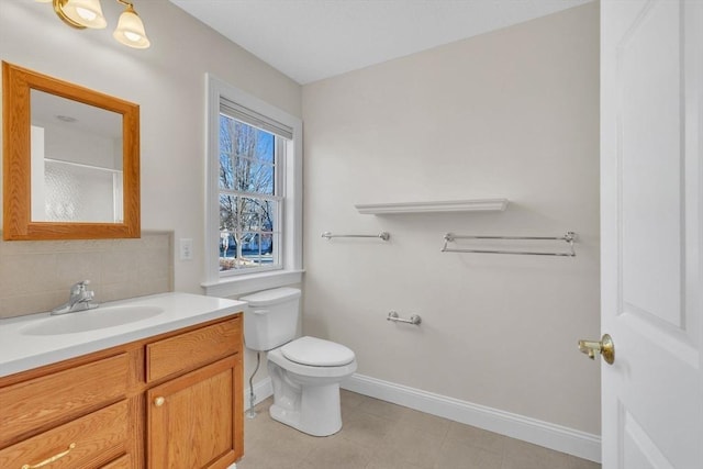 bathroom with tasteful backsplash, vanity, tile patterned floors, and toilet