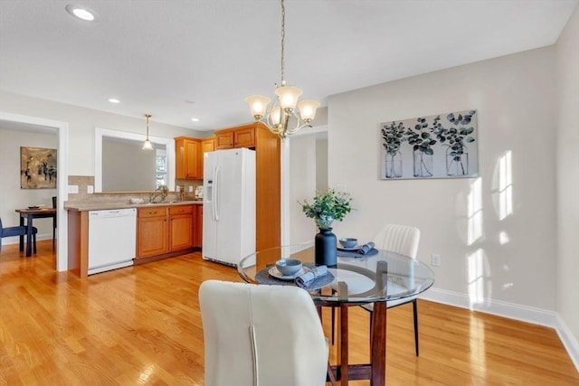 dining area featuring a chandelier, light hardwood / wood-style floors, and sink