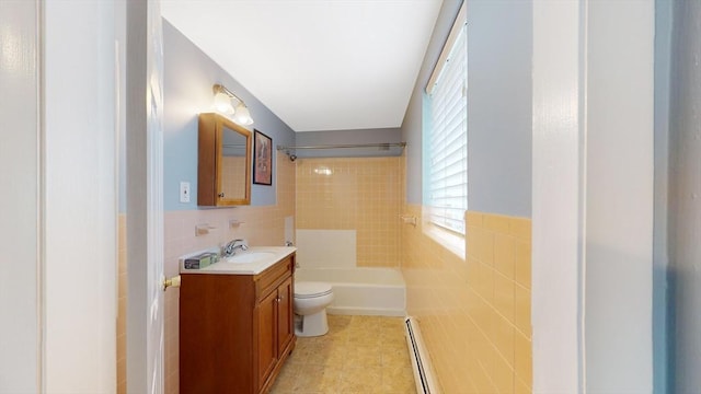 full bath with toilet, a baseboard heating unit, tile walls, and vanity