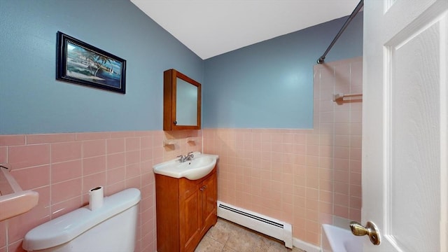 bathroom with tile walls, toilet, baseboard heating, wainscoting, and tile patterned floors