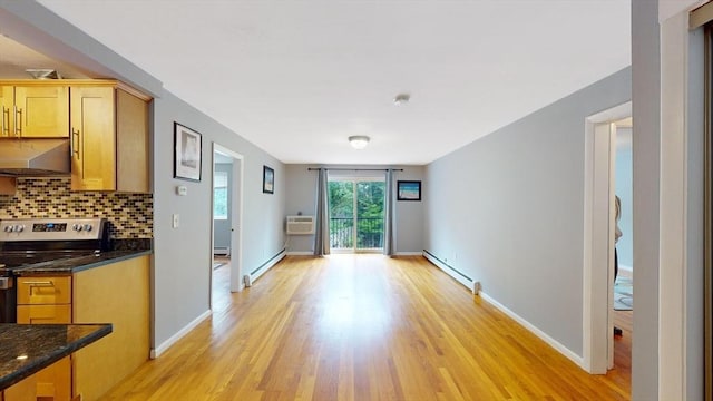 interior space with light wood-type flooring, a baseboard radiator, and baseboards