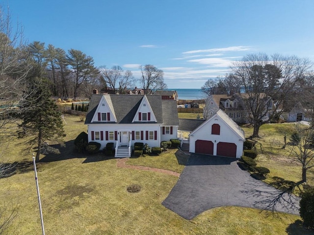 view of front of house featuring an outbuilding, a front yard, and a detached garage