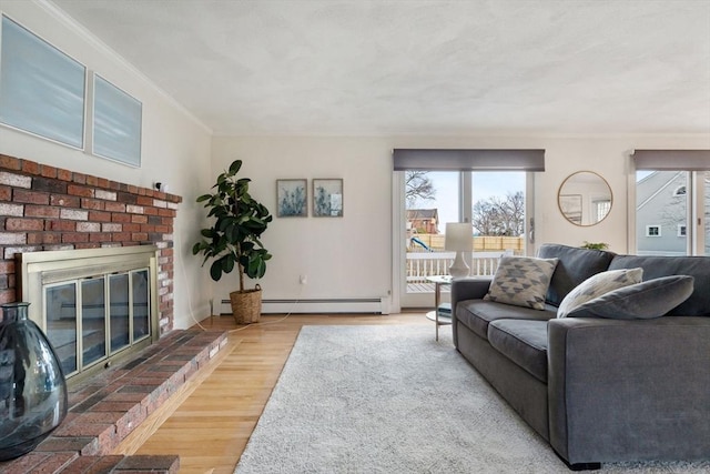 living room featuring a baseboard radiator, a brick fireplace, crown molding, and wood finished floors