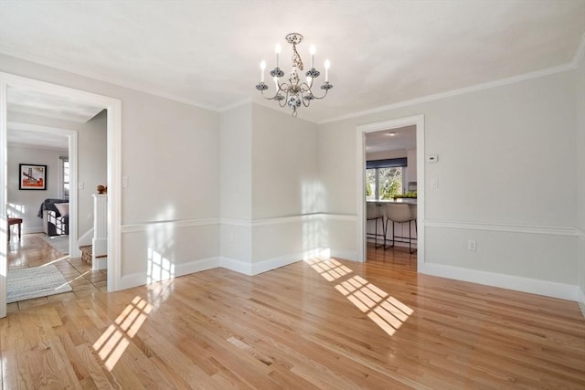 spare room featuring a baseboard heating unit, wood finished floors, crown molding, baseboards, and a chandelier