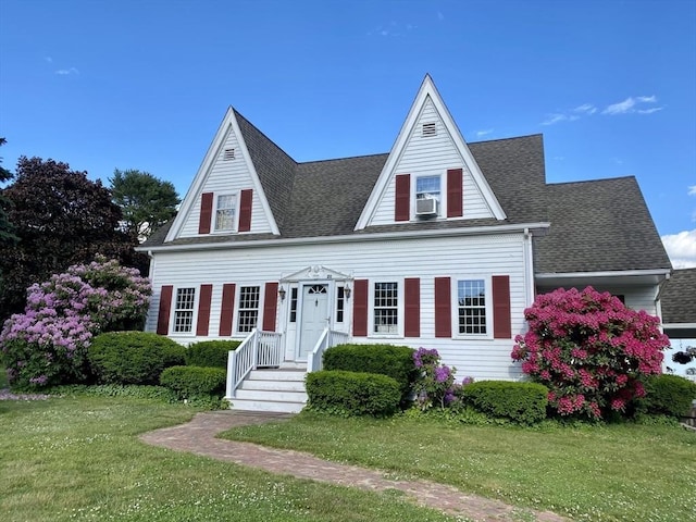 view of front of property with a front lawn, cooling unit, and roof with shingles