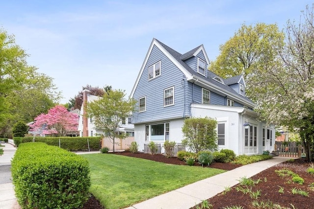 view of property exterior featuring a lawn and fence