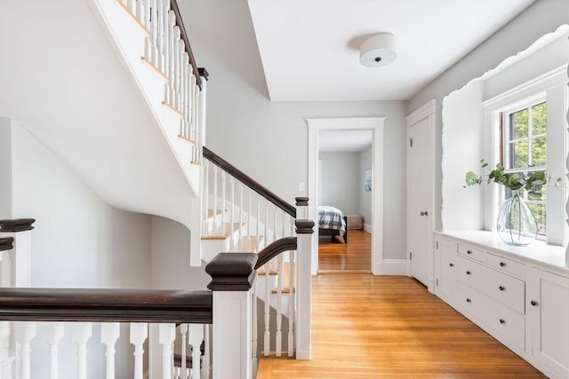 foyer with stairway, baseboards, and light wood-type flooring