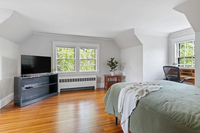 bedroom featuring radiator, multiple windows, and vaulted ceiling