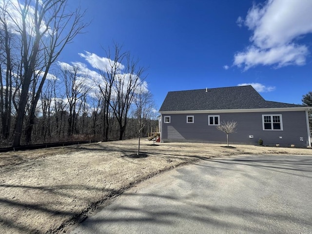 view of property exterior with roof with shingles