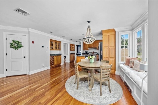 17 Maplewood Dr, Hanover, MA 02339 - dining area with a chandelier, light wood-style floors, a dry bar, and ornamental molding