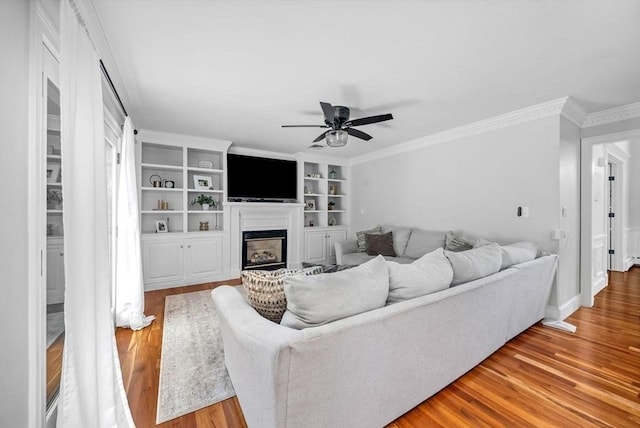 17 Maplewood Dr, Hanover, MA 02339 - living area featuring wood finished floors, a ceiling fan, crown molding, a fireplace, and built in features