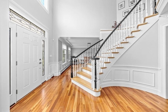 17 Maplewood Dr, Hanover, MA 02339 - foyer entrance with a high ceiling, stairway, wood finished floors, a decorative wall, and a wainscoted wall