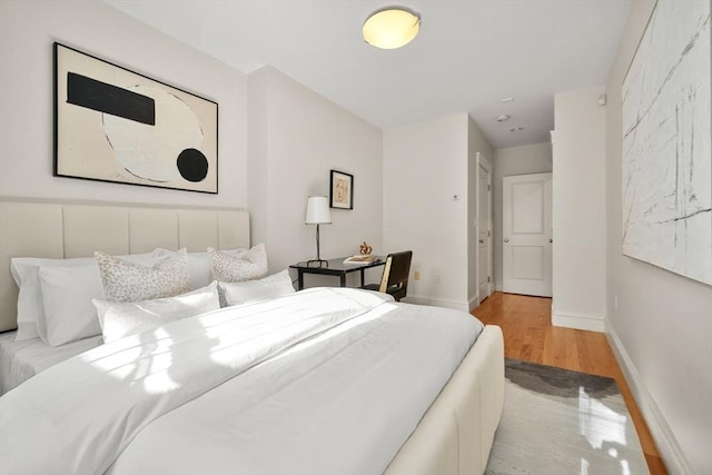 bedroom featuring wood finished floors and baseboards