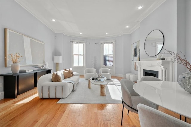 living area with light wood finished floors, ornamental molding, a fireplace, recessed lighting, and baseboards