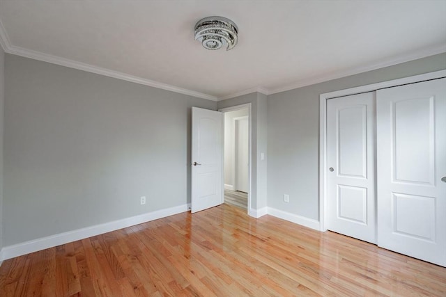 unfurnished bedroom with a closet, ornamental molding, and light hardwood / wood-style flooring