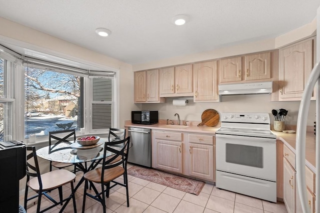 kitchen with stainless steel appliances, light brown cabinetry, and light tile patterned floors