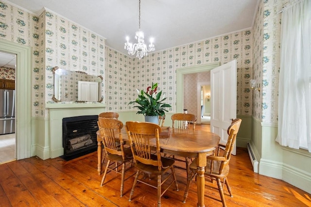 127 E St, East Bridgewater, MA 02333 - dining space with wallpapered walls, ornamental molding, wainscoting, light wood-style floors, and a fireplace with flush hearth