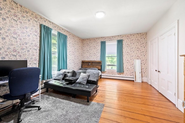 127 E St, East Bridgewater, MA 02333 - bedroom featuring light wood-style floors, a baseboard heating unit, multiple windows, wallpapered walls, and a desk
