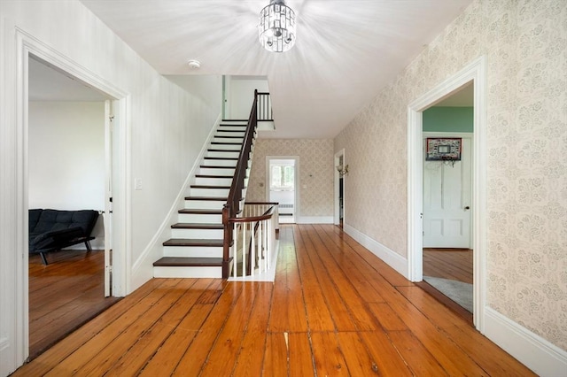 127 E St, East Bridgewater, MA 02333 - staircase with wallpapered walls, hardwood / wood-style flooring, a chandelier, and baseboards