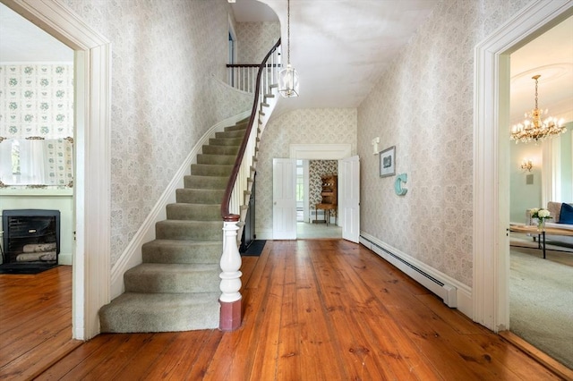 127 E St, East Bridgewater, MA 02333 - foyer entrance featuring wallpapered walls, a baseboard radiator, hardwood / wood-style flooring, stairway, and a chandelier