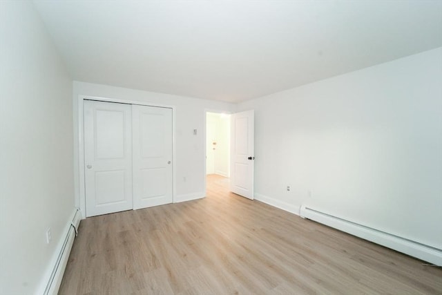 80 Main St Unit 4, Malden, MA 02148 - unfurnished bedroom featuring baseboard heating, light wood-style floors, a baseboard radiator, a closet, and baseboards