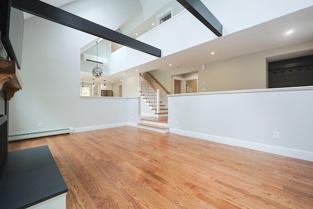 93 Hollis Rd, Plymouth, MA 02360 - unfurnished living room featuring baseboard heating, wood finished floors, high vaulted ceiling, recessed lighting, and baseboards