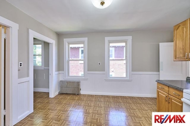 150 Nonantum St, Boston, MA 02135 - unfurnished dining area featuring radiator heating unit and wainscoting