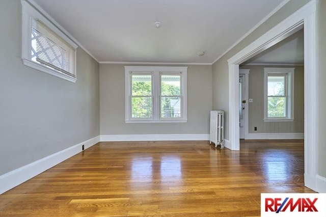 150 Nonantum St, Boston, MA 02135 - unfurnished living room with radiator, baseboards, wood finished floors, and ornamental molding