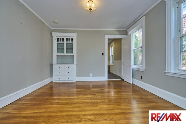 150 Nonantum St, Boston, MA 02135 - spare room with ornamental molding, wood finished floors, healthy amount of natural light, and baseboards
