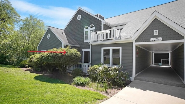 view of front of property featuring a balcony and a front lawn