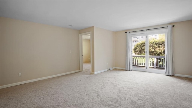 empty room featuring carpet flooring and baseboards