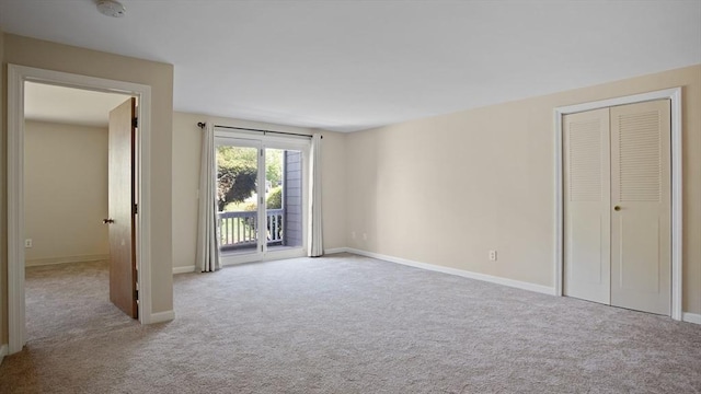 unfurnished bedroom with access to exterior, carpet floors, and baseboards