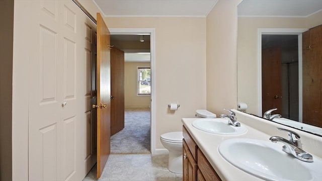 full bathroom with double vanity, toilet, tile patterned flooring, crown molding, and baseboards
