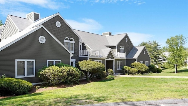 view of front of house featuring a chimney and a front lawn