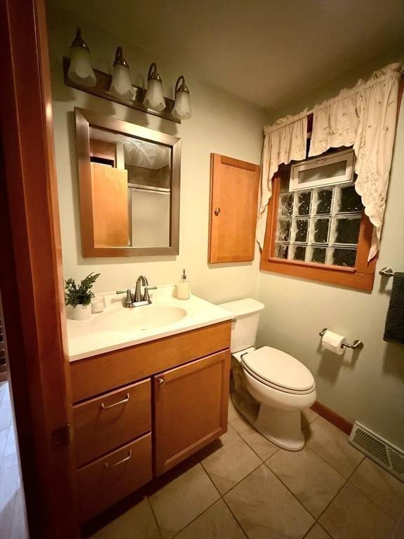 bathroom featuring visible vents, baseboards, toilet, tile patterned flooring, and vanity