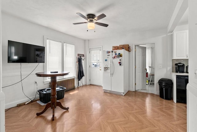 381 Hunnewell St Unit 381, Needham, MA 02494 - kitchen featuring white refrigerator with ice dispenser, ceiling fan, white cabinetry, radiator heating unit, and baseboards