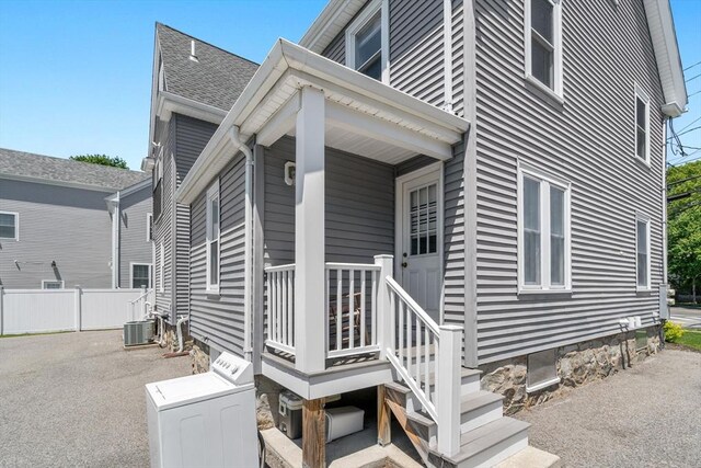 381 Hunnewell St Unit 381, Needham, MA 02494 - view of property exterior featuring washer / dryer, central air condition unit, and roof with shingles