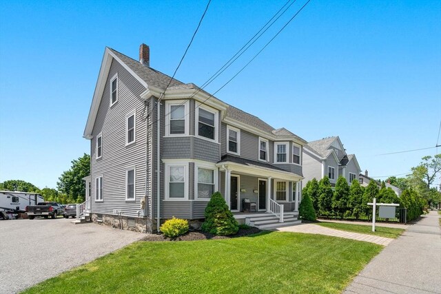 381 Hunnewell St Unit 381, Needham, MA 02494 - view of front of house featuring covered porch, a chimney, and a front yard