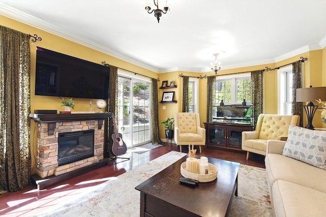 living room featuring a stone fireplace, crown molding, a notable chandelier, and wood finished floors