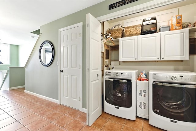 washroom featuring baseboards, cabinet space, separate washer and dryer, and light tile patterned flooring