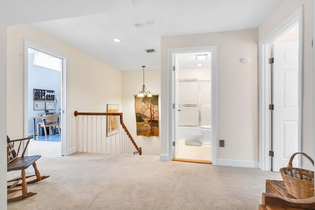 hall with an upstairs landing, carpet flooring, baseboards, and visible vents