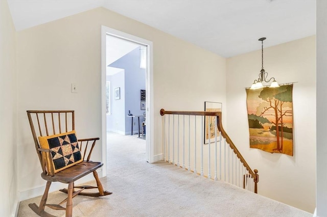 corridor with baseboards, an upstairs landing, an inviting chandelier, and carpet flooring