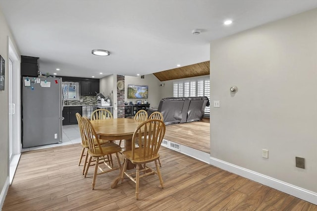 dining area with recessed lighting, baseboards, light wood-style flooring, and vaulted ceiling