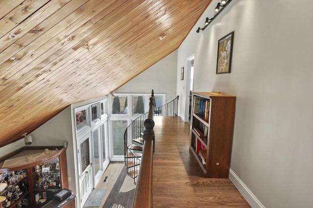 hall featuring an upstairs landing, lofted ceiling, wood finished floors, baseboards, and wood ceiling