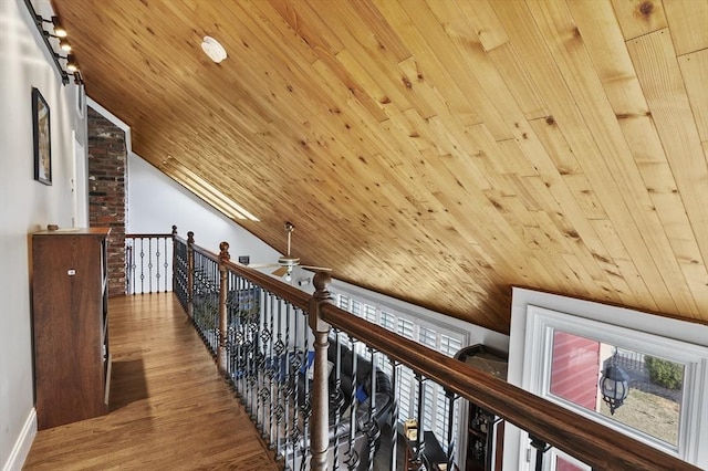 hallway with wood finished floors, an upstairs landing, wood ceiling, and vaulted ceiling