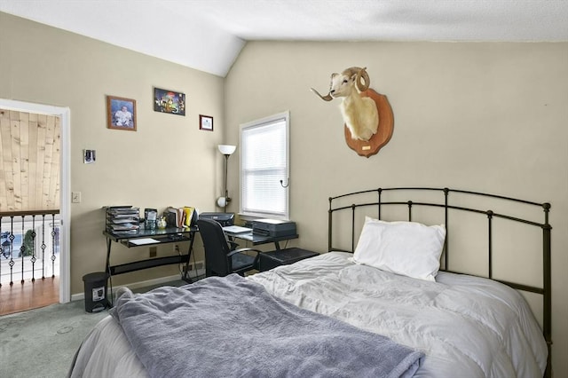 bedroom featuring baseboards, lofted ceiling, and carpet flooring