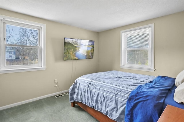 bedroom featuring multiple windows, carpet flooring, baseboards, and visible vents