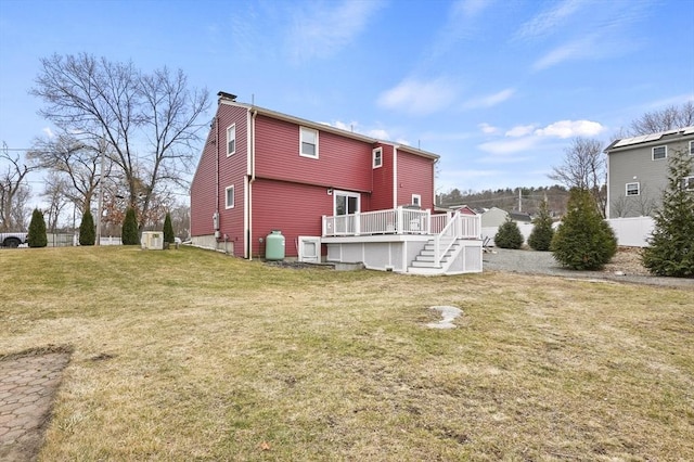 back of house featuring stairs, a wooden deck, a yard, and a chimney